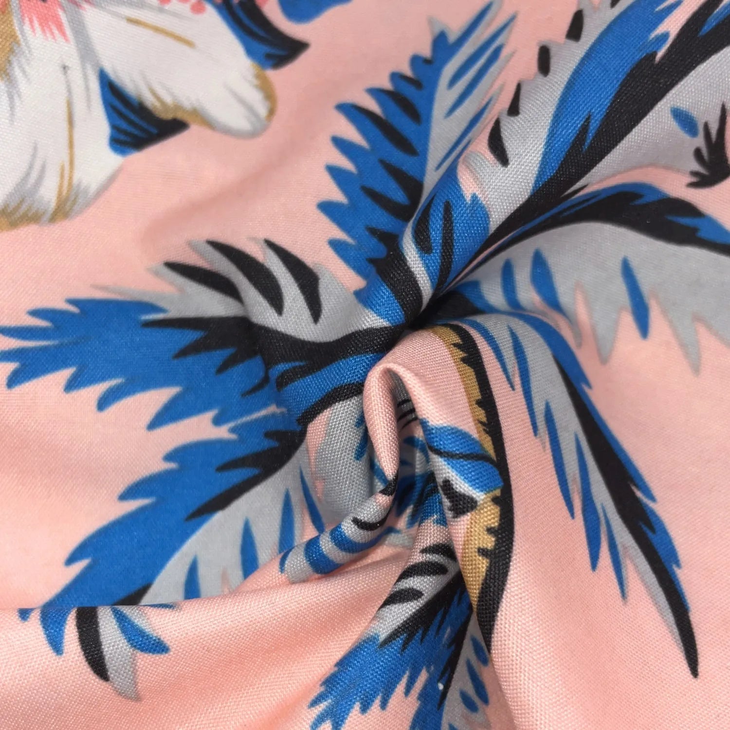 Primer plano de la tela de la camisa hawaiana rosa con palmeras y flores tropicales.