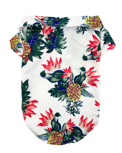 Camisa hawaiana para perros con estampado floral brillante y piñas sobre fondo blanco.